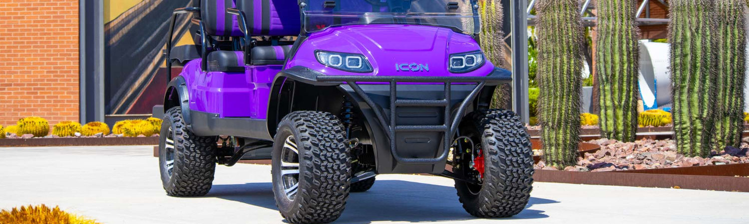 A bold purple golf cart with rugged tires and black accents